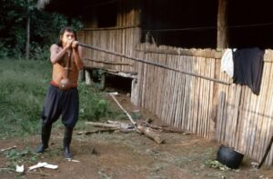 A member of an Amazonian indigenous tribe demonstrates the use of a blowgun. 