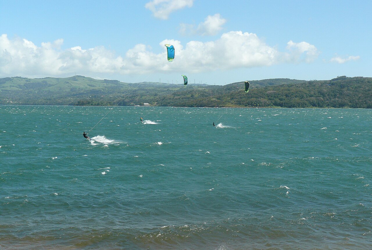 Kite-surfing on Lake Arenal, Costa Rica's largest lake. Created in 1979 via the construction of the Presa Sangregado dam, Lake Arenal expanded to cover a much smaller, natural lake which existed in the area. c/o Presa Sangregado, wikicommons.