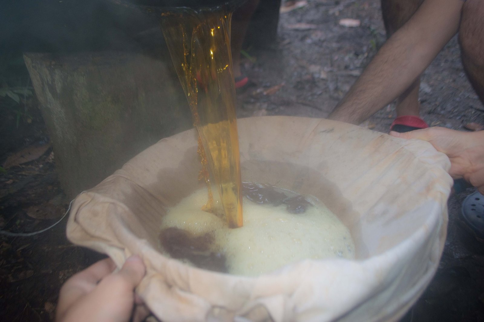 Ayahuasca being prepared by plant medicine center attendees, supervised by a helper of the curandero.